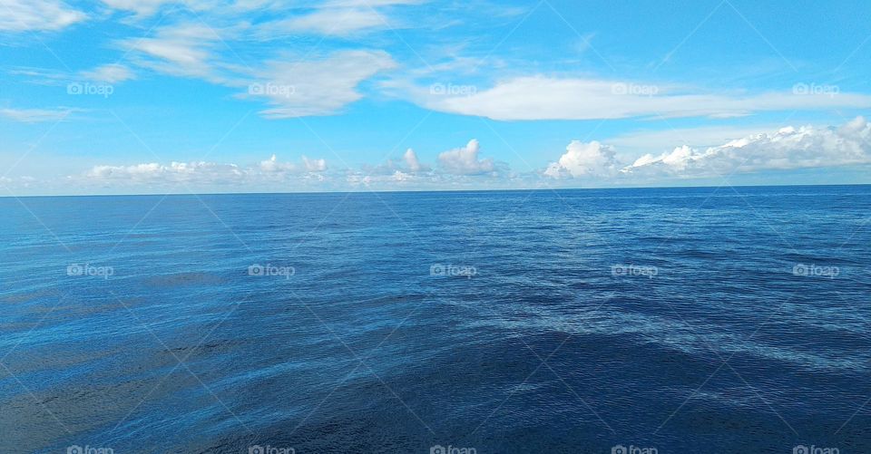 Cloudscape on the sea, a beautiful combination of clouds adorn the clear sky.