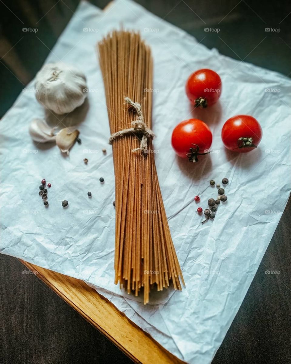 ingredients for making pasta. tomatoes, spaghetti, garlic and spices
