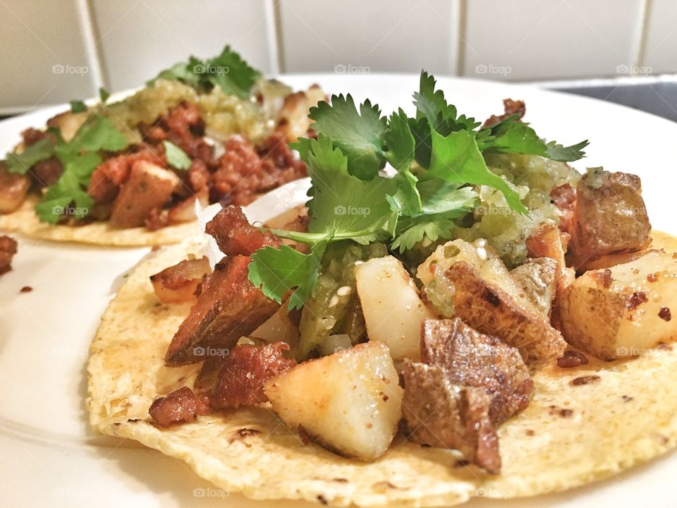 Authentic homemade Crispy fried Chorizo and Papas Tacos on a homemade corn tortilla and topped with cilantro. 