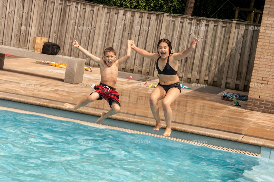 Brother and sister jumping in together