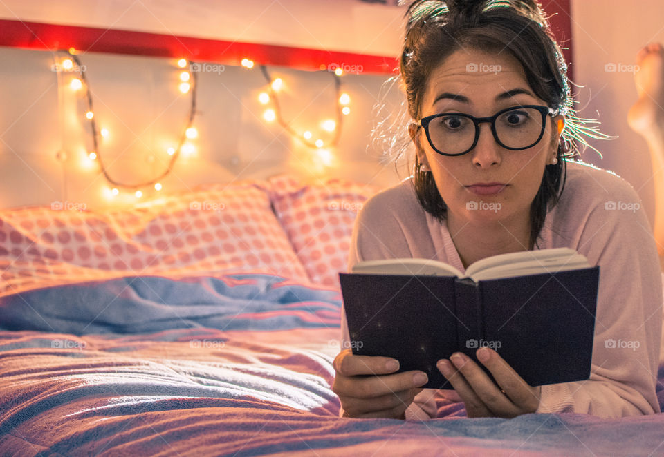 Cute girl reading in bed