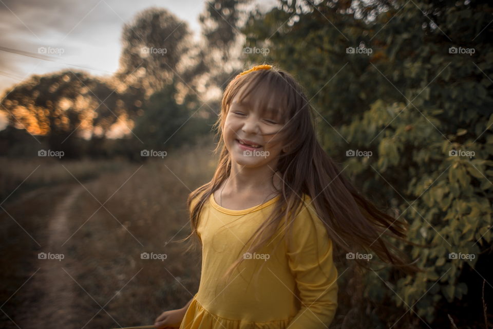 Little girl in yellow dress outdoor portrait at sunset 