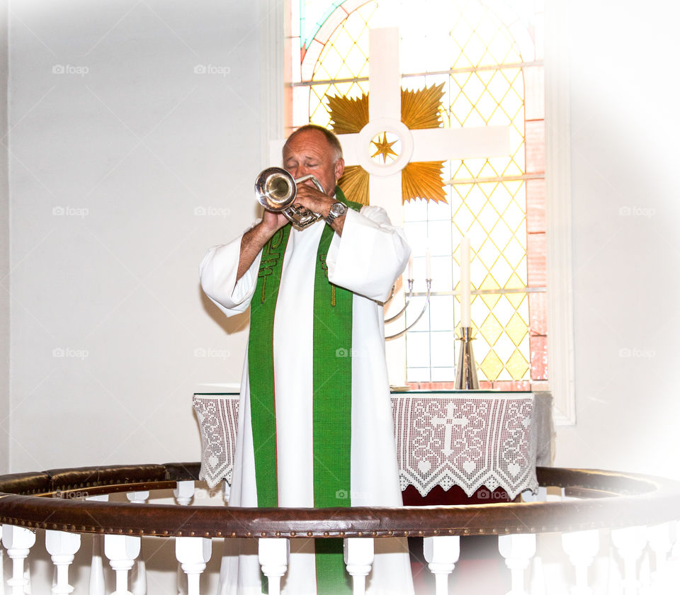 Priest playing trumpet. 