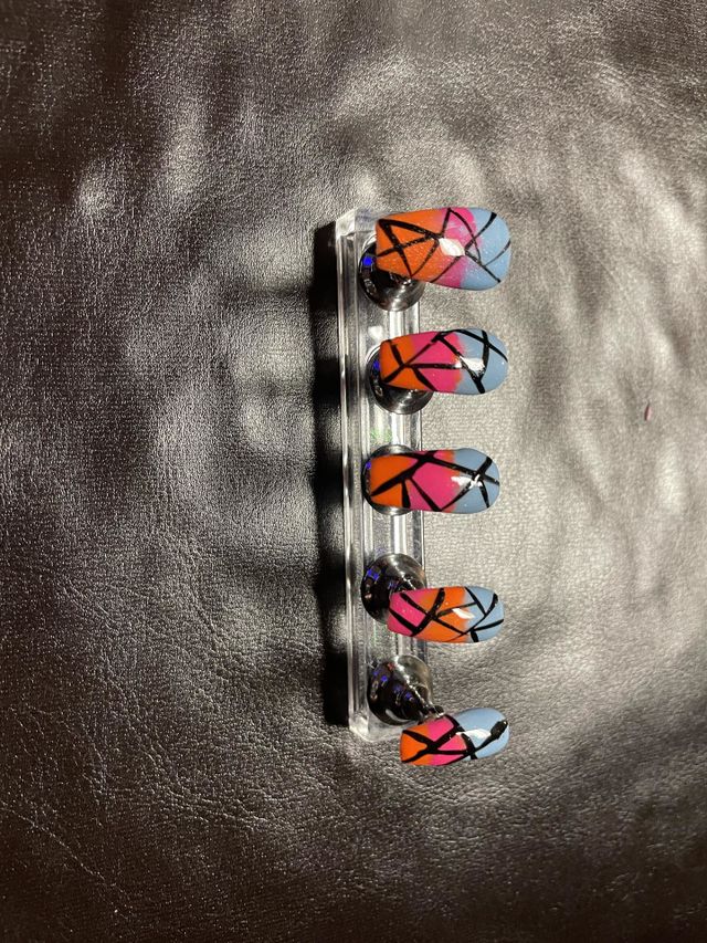 Blue, orange, and pink nail set with black stripes.