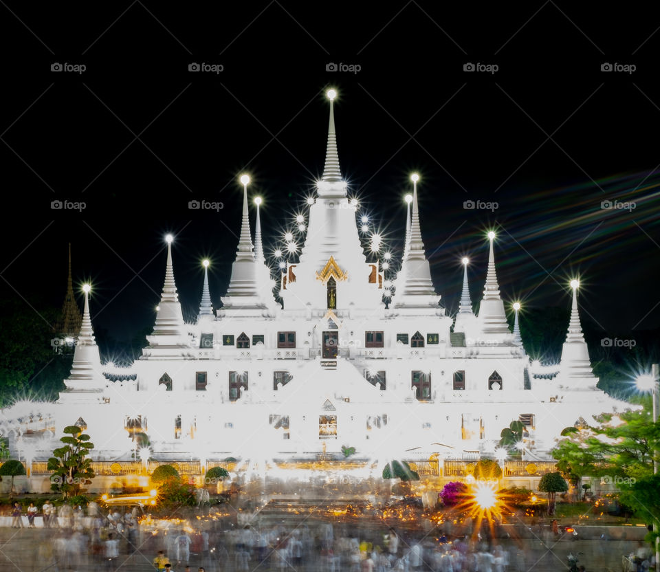 Thailand-Febuary 08 2019:Line of Monks walk around the pagoda with candle at Wat Asokkaram in Magha Puja Day is held on the Day of the full moon of the third lunar month 