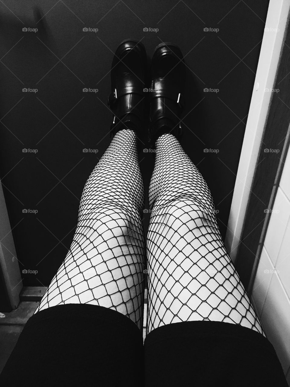 Fishnet stockings and boots on a girls legs