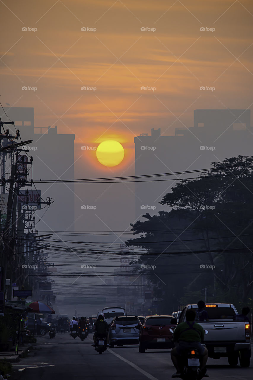 The early morning sunlight shining on buildings and the cars on the road at Bangyai City of Nonthaburi in Thailand.  January 14, 2019