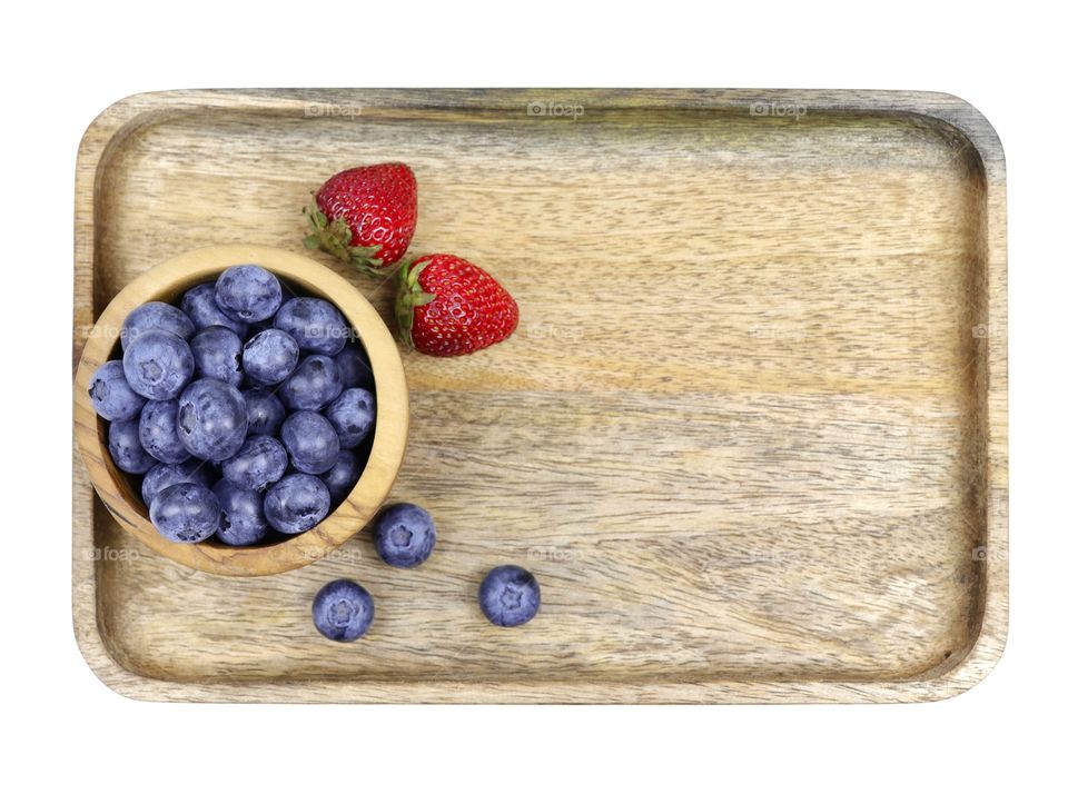 Blueberries and strawberries in wooden bowl 