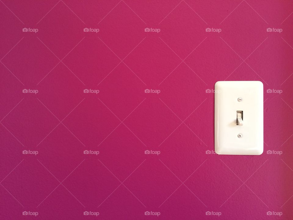 Close-up of pink wall and light switch