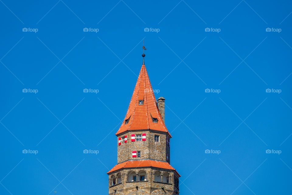 The tower of the famous Czech castle Bouzov with a typical roof and shutters.