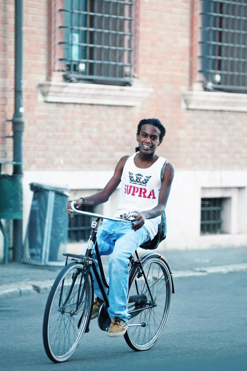 Smiling young man on the bicycle