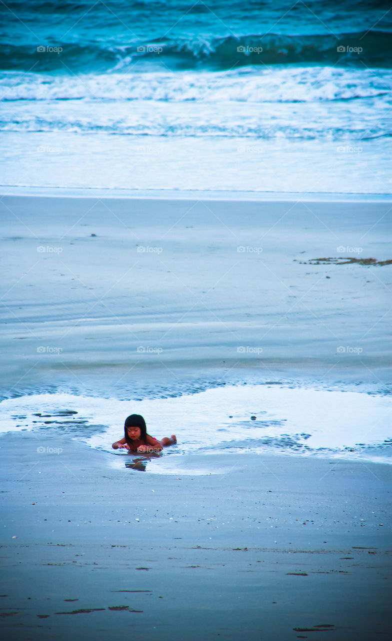 Little girl swimming in the sea and enjoy the beach during the summer holidays.