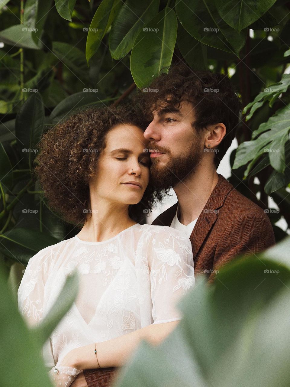 Young beautiful lovers in botanical garden 