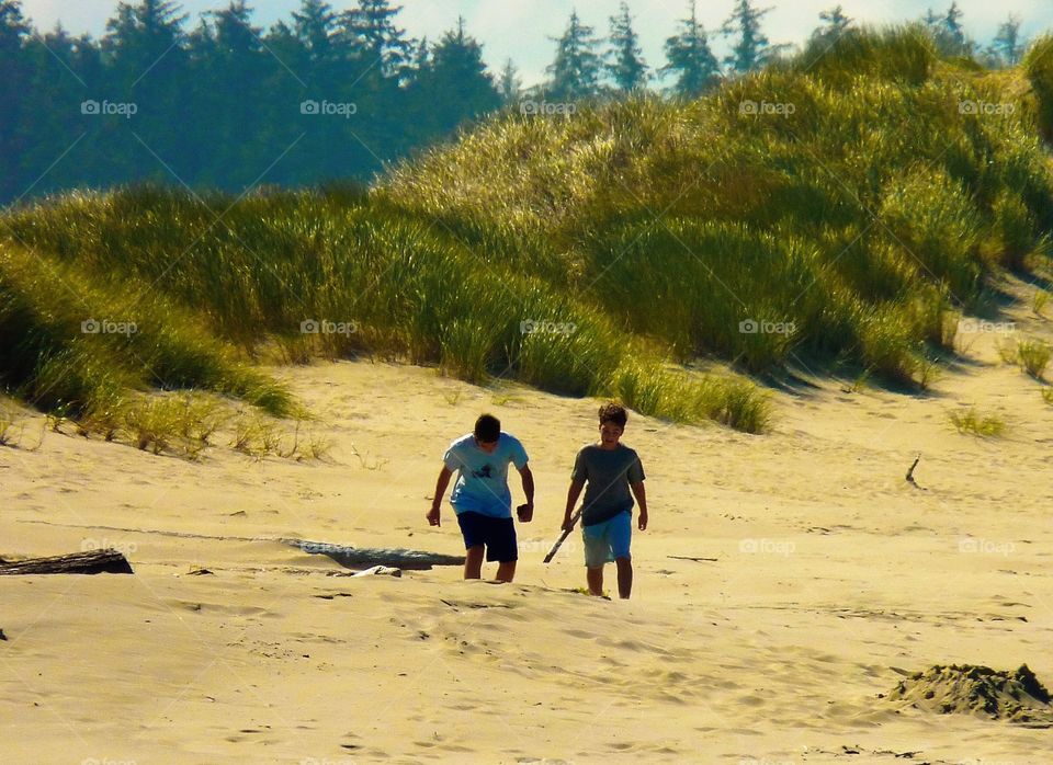 Boys walking on Cannon Beach, Oregon