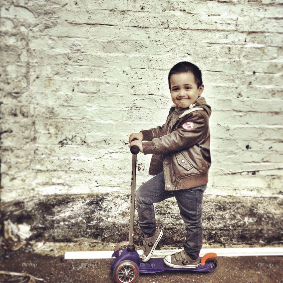 A little boy on micro scooter