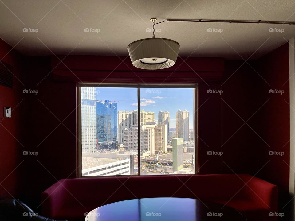 Room with retro lamp and window with view to cityscape and skyscrapers 