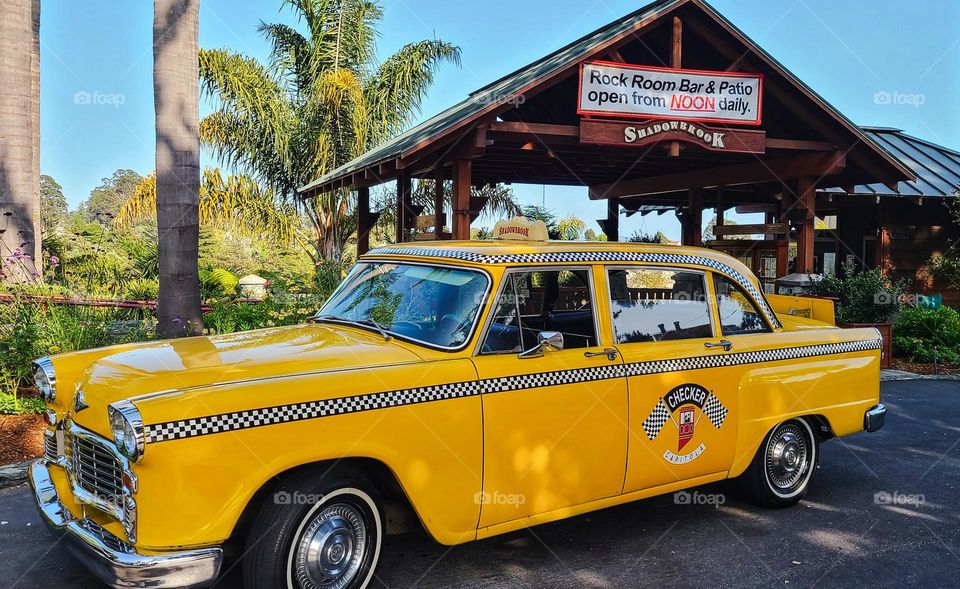 Vintage yellow checkered taxicab outside a restaurant 