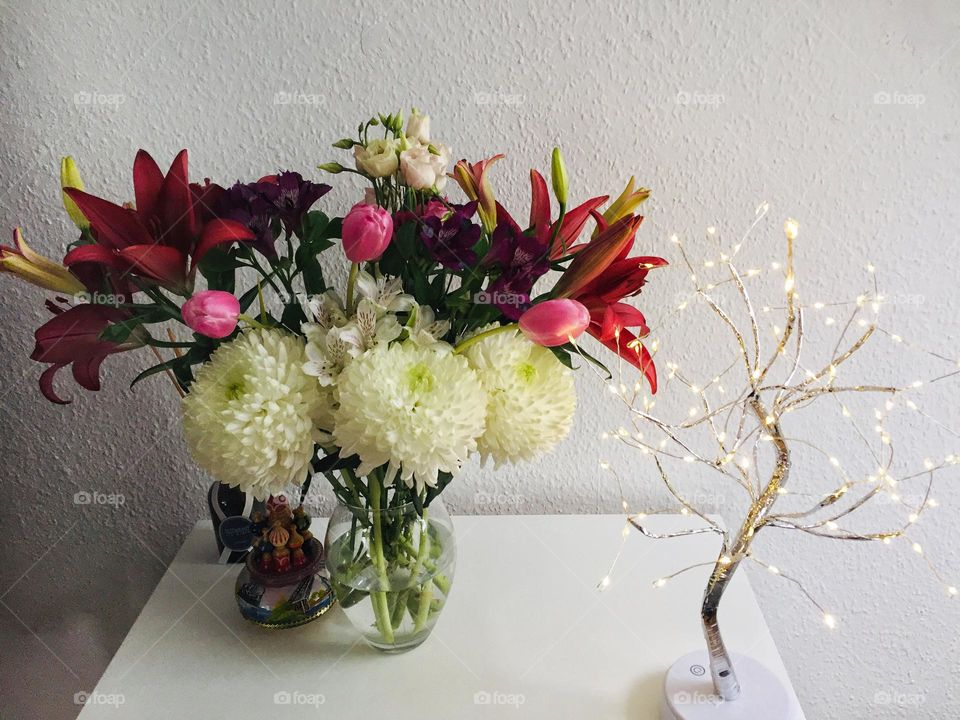 Favourite chest of drawers with fresh flowers and comfortable light.