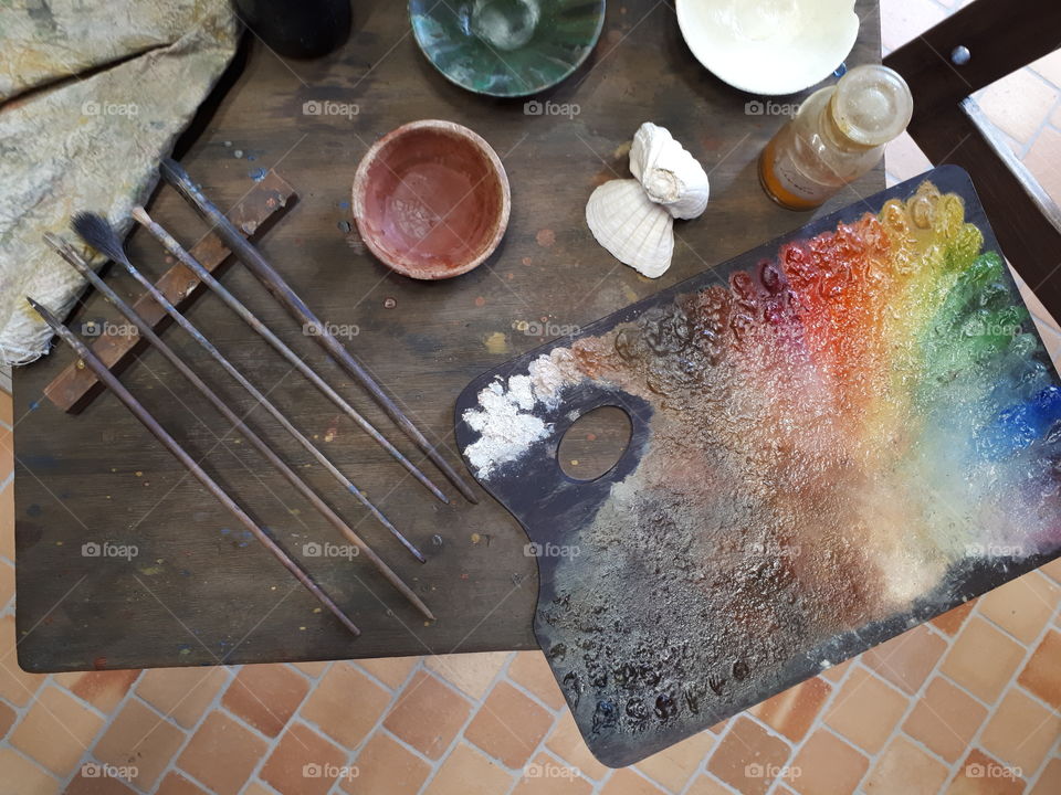 Old table with brushes and palette of colors