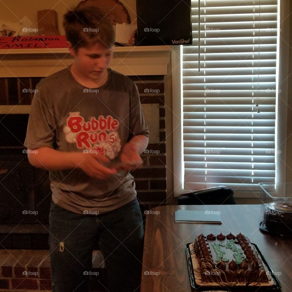 Boy standing front of cake