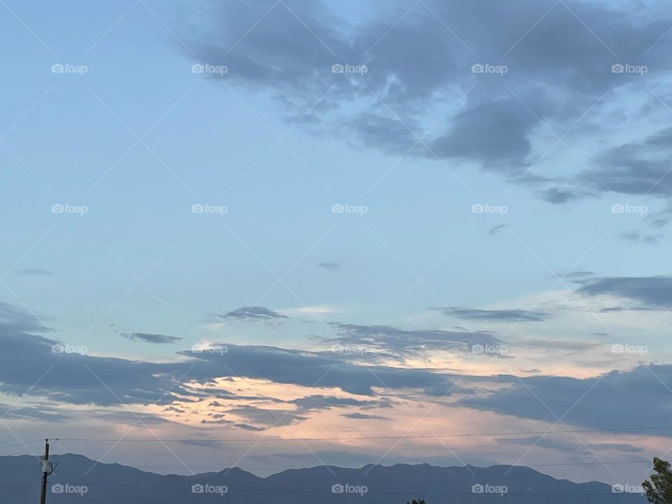A sunset with clouds and mountains.