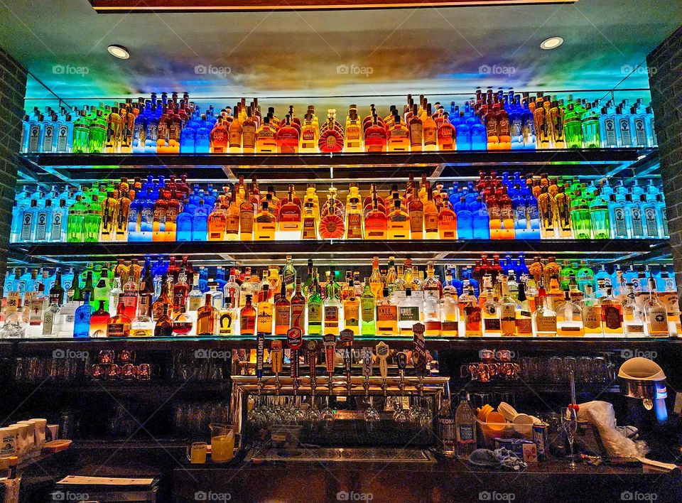 Colorful bottles of assorted alcohols creates a beautiful bar background