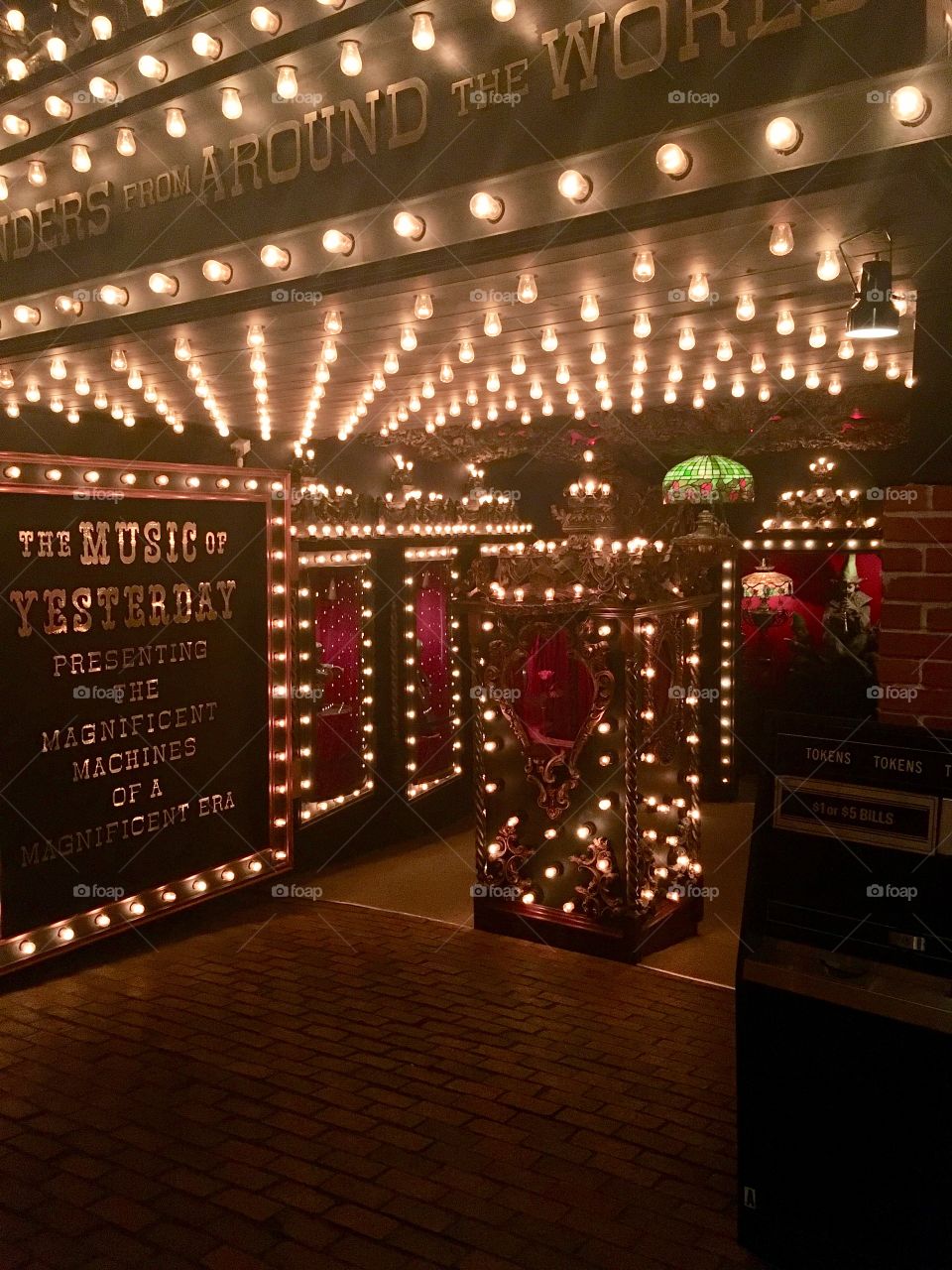The entrance to an old theater with rows of lights and deep red accent colors with a large monicker sign announcing the show. House on the Rock, WI