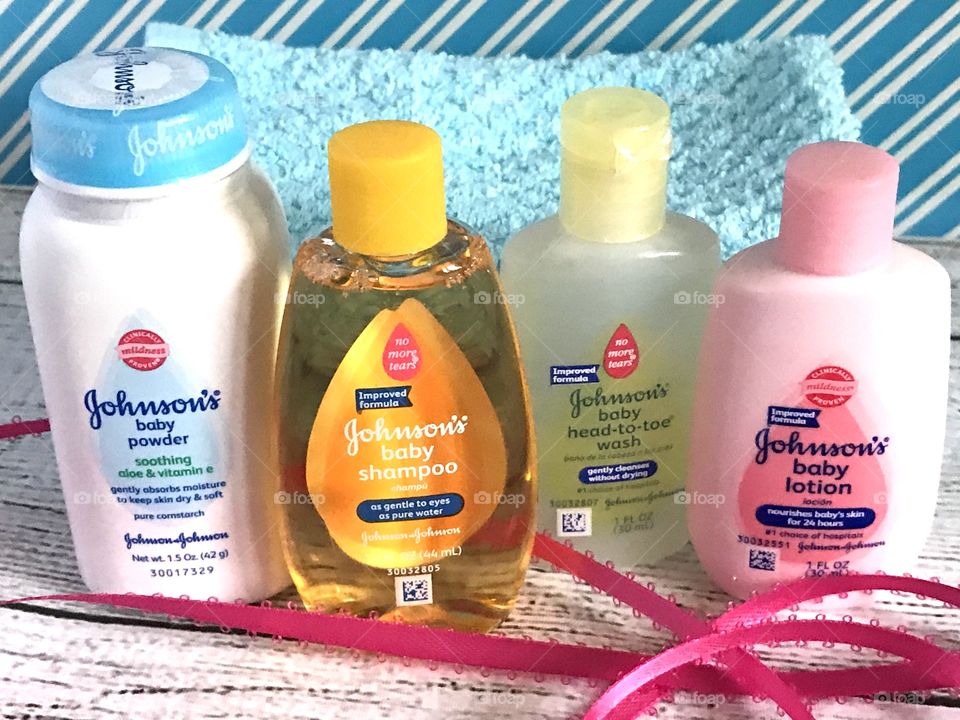 Johnson and Johnson baby lotion, shampoo, head to toe wash and powder on a blue and white background with a pink ribbon 