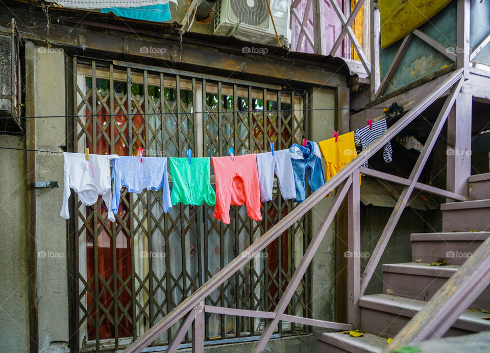 view of the outside of the household, colorful clothes dries on ropes on clothespins