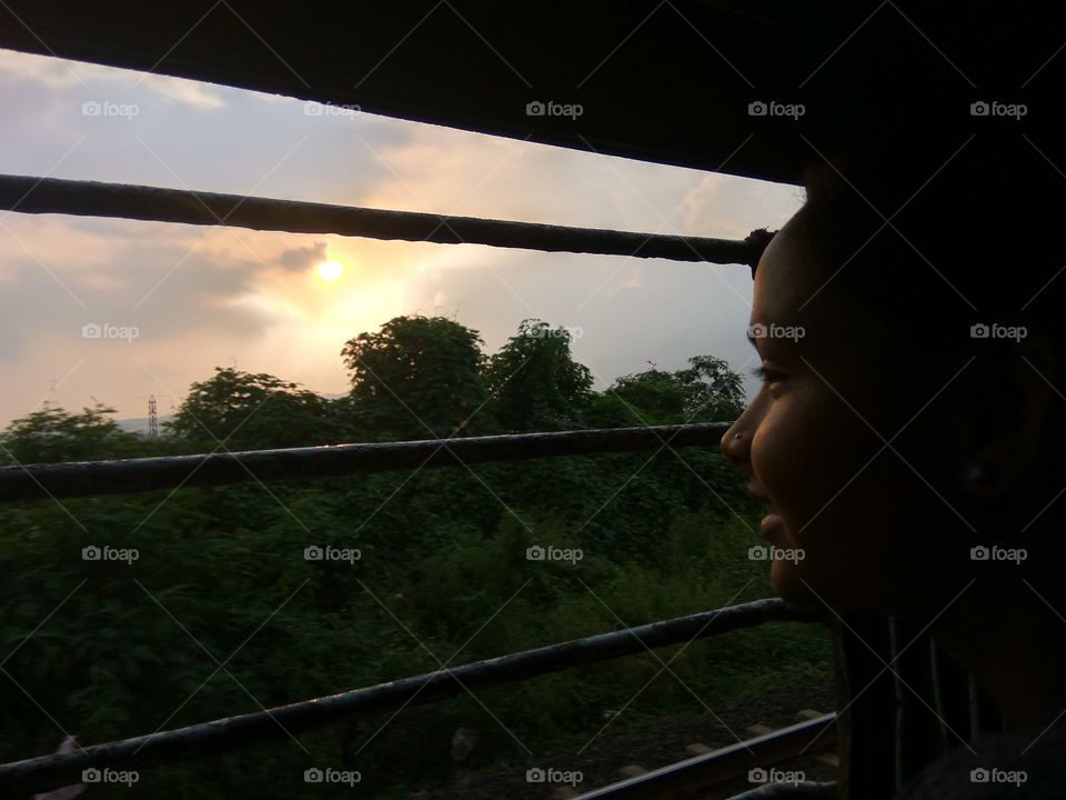 sky 
jungle 
moving train Window 
girl look at sun