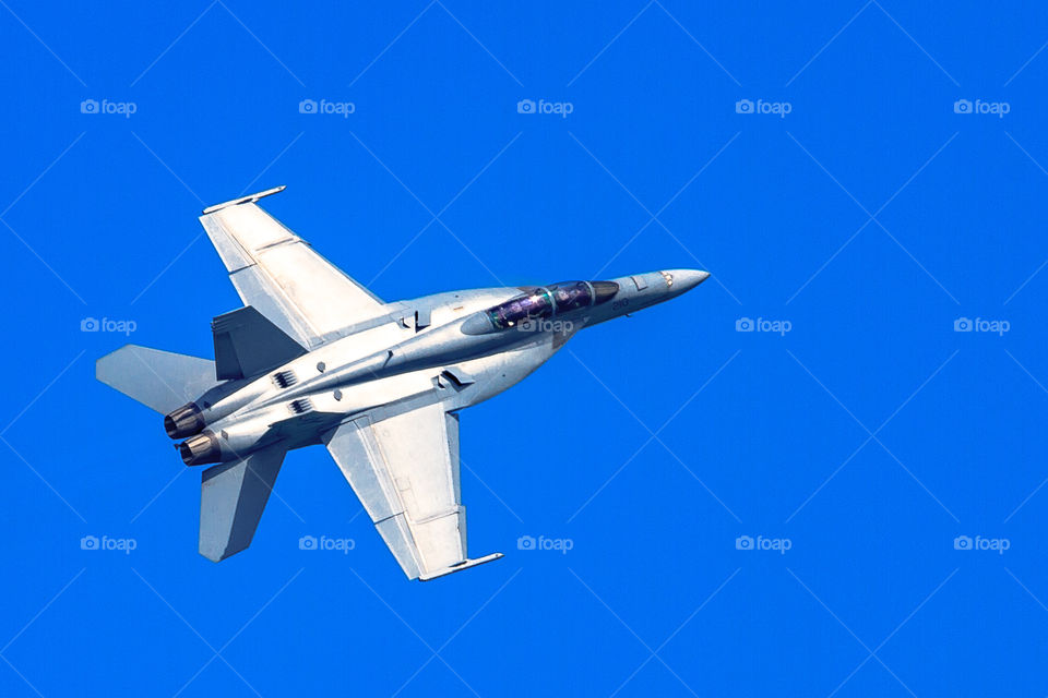F-18 alone against a clear blue sky