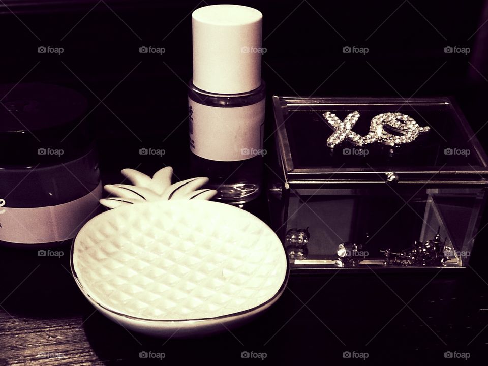 Display of glass pineapple and jewelry and perfume 