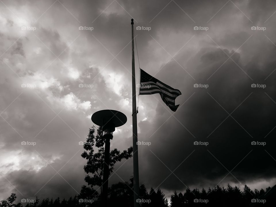 Flag and lamppost with storm clouds behind