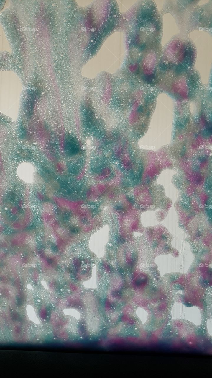 window covered in colored soap at car wash