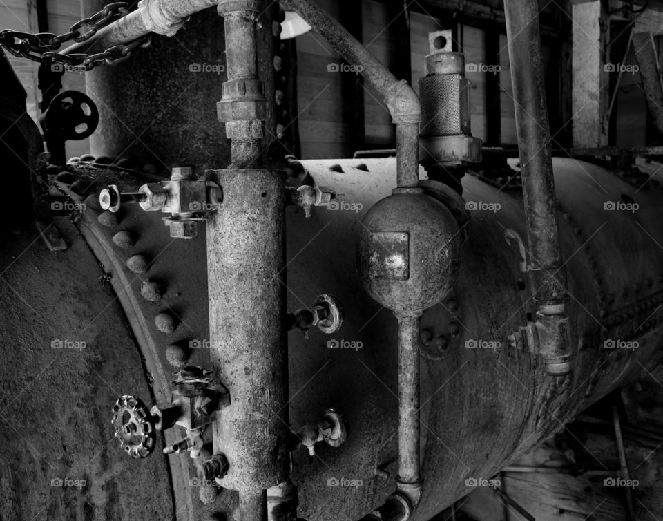 Old rusted iron steam pipes on an industrial machine. 