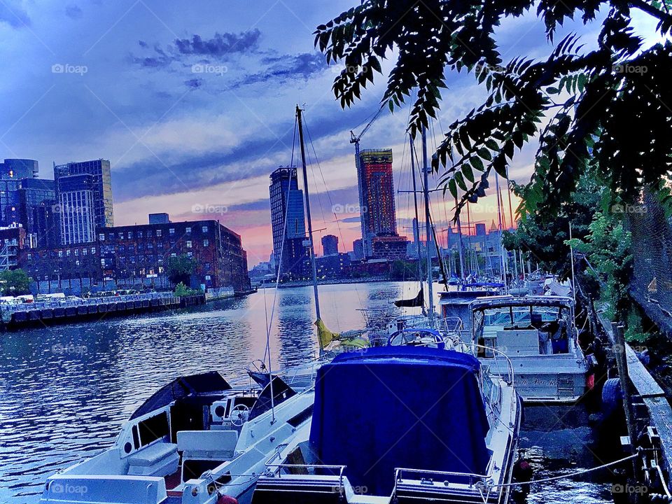 Newtown Creek in the post sunset twilight hour with its boats, motor boats, sailboats with or without outboard motors and tiny “dinghies” which are rowboats that take you to & fro the boat from the shore and vice versa. 2019. Hypnotic Productions