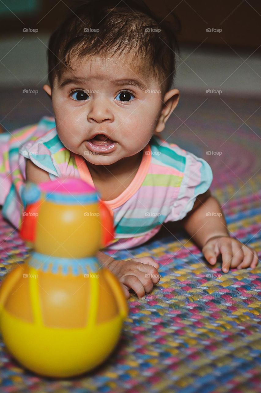 Surprised baby looking at camera, toy surprises baby, baby girl showing emotion of surprise, facial expressions of surprise, surprised at the clown toy, 1970’s clown toy, vintage baby clown toy