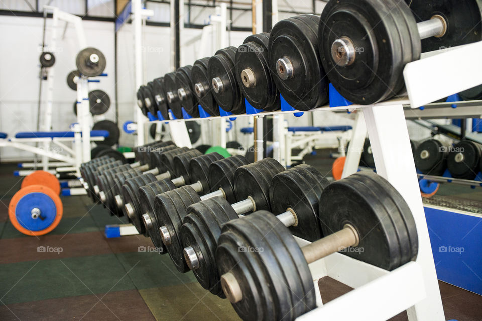 Rows of dumbbells in the gym. Dumbbells on the rack in the sports hall of the club