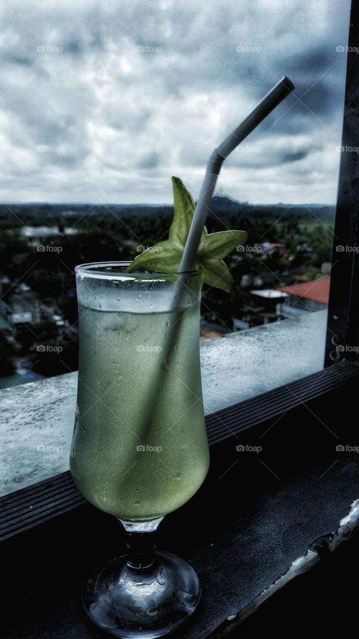 lemon juice glass decorate with star fruit/ cool drink / In the evening / dark and beautiful sky / dark background / different perspective / liquids / Sri Lanka / edited