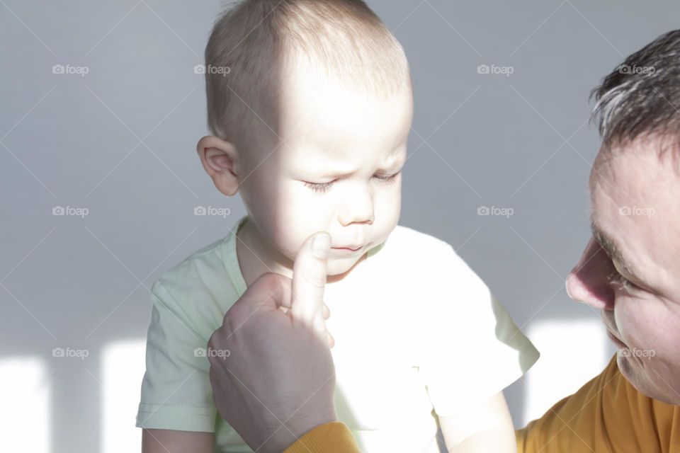 Dad teaches a small child to paint and have fun together.