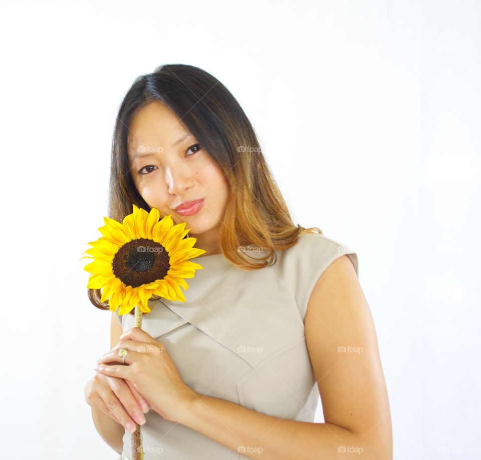 Sunflower Girl. Woman poses with a sunflower. 