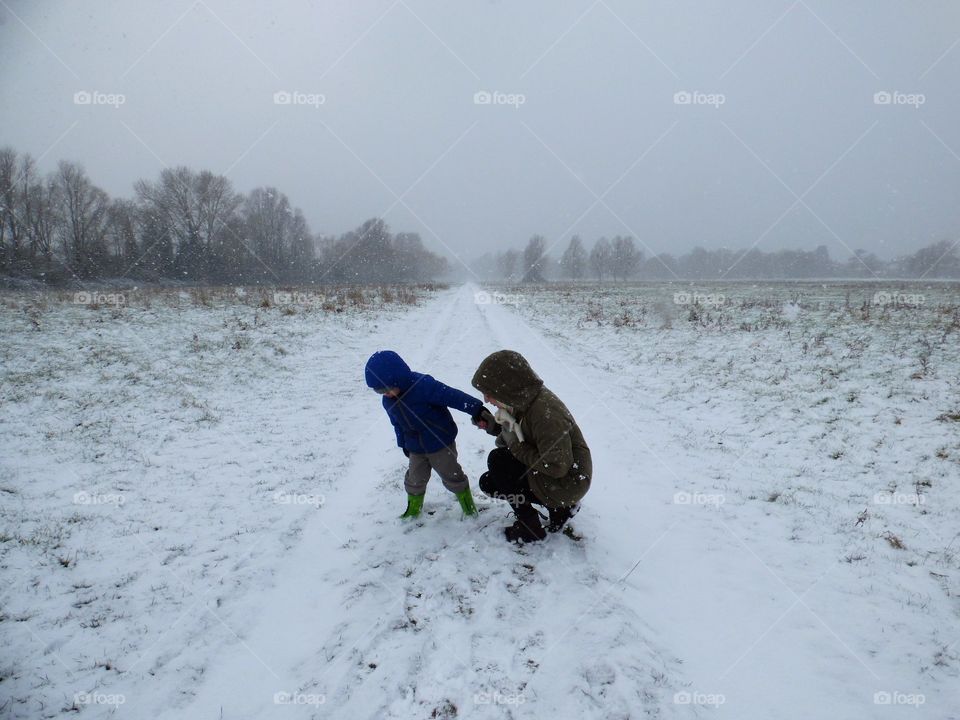 mother and son playing on the snow