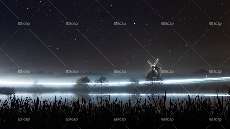 A long shutter and a car passing by a mill at night. Love the way the light curves.