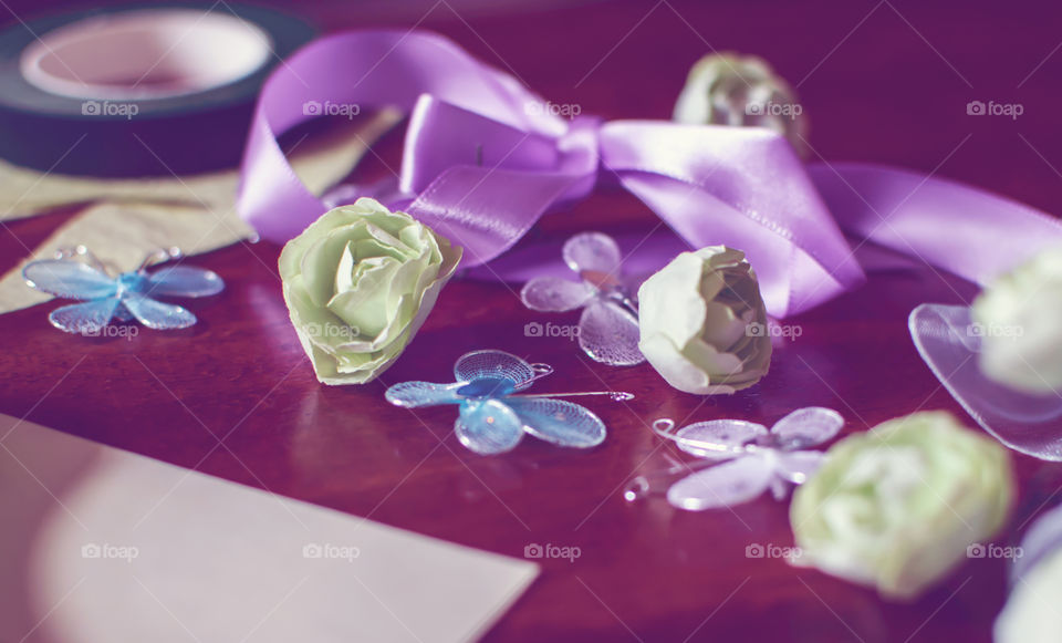 Soft conceptual background with arts and crafts supplies, paper flowers, ribbon and bows, butterflies springtime hand made cards 