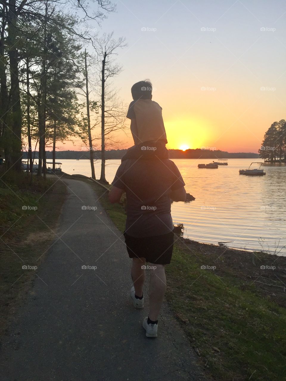 Dad walking son at sunset 