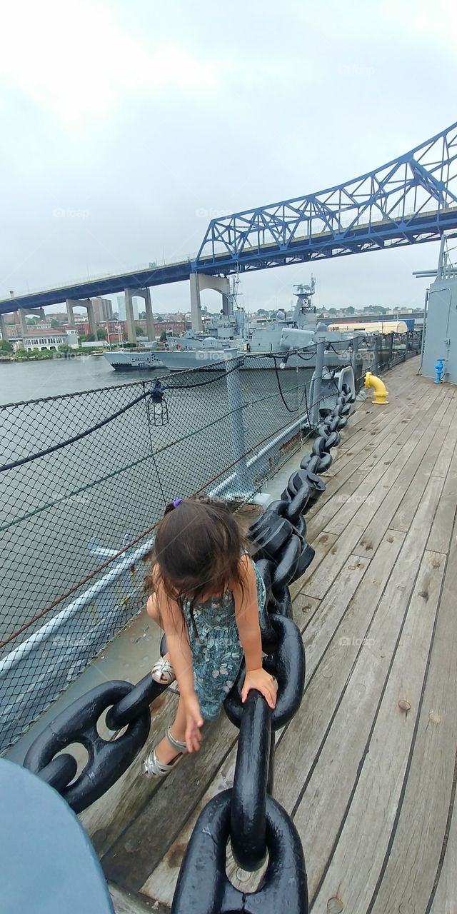 young child climbing a giant chain