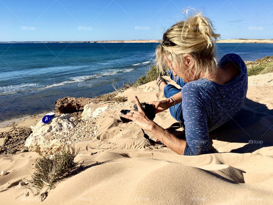 Myself (middle age blond adult female) On a self assignment in South Australia shooting for a Nivea FOAP mission, atop a sand swept hill overlooking the ocean 