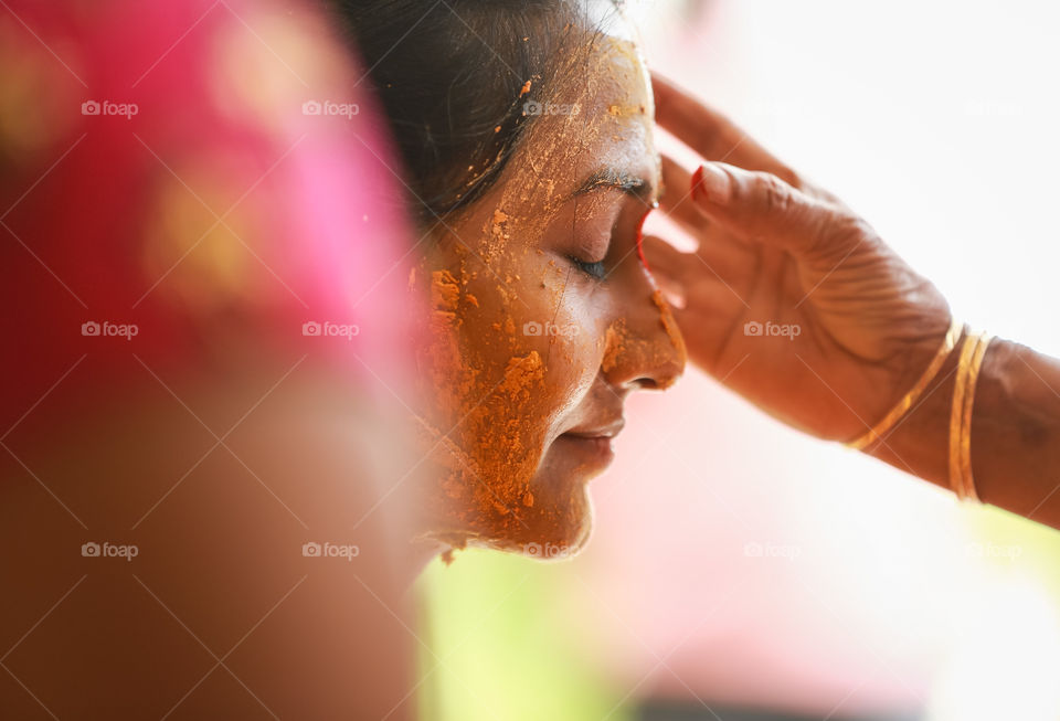 Portrait of an Indian women with turmeric on her face on her wedding day shot with DSLR camera