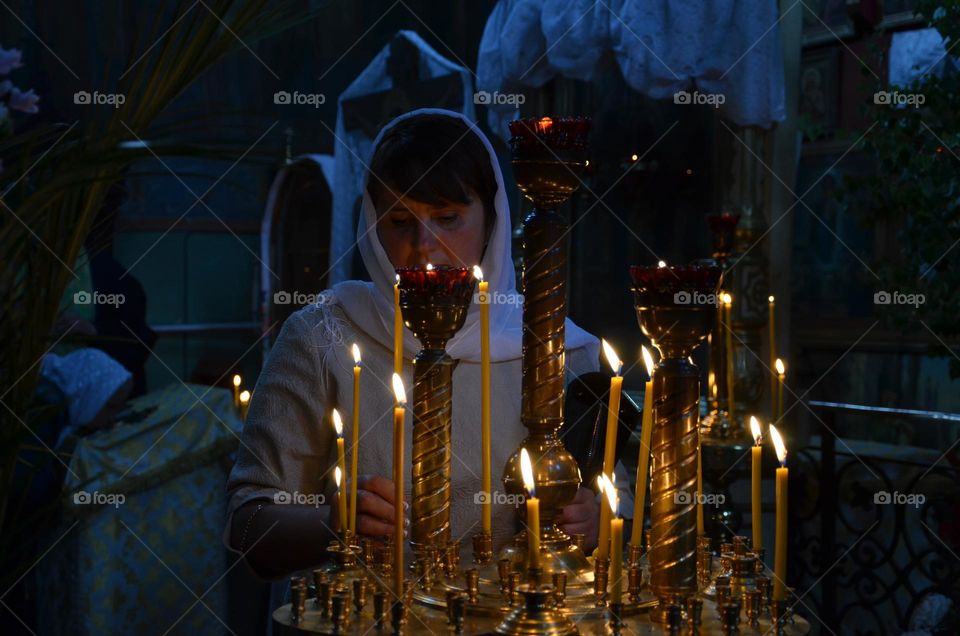 A woman puts a candle in a Christian church