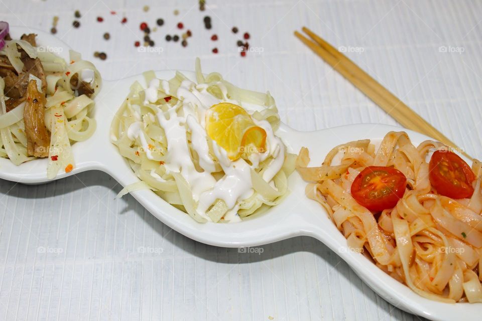 Rice noodles with white cream,  tomatoes and oyster mushrooms on a  wooden background